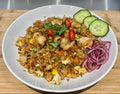 Fried rice dish with vegetables and garnishes. 