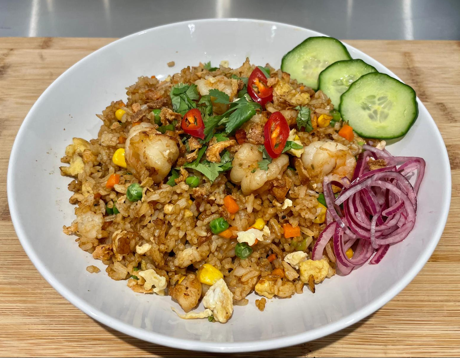 Fried rice dish with vegetables and garnishes. 
